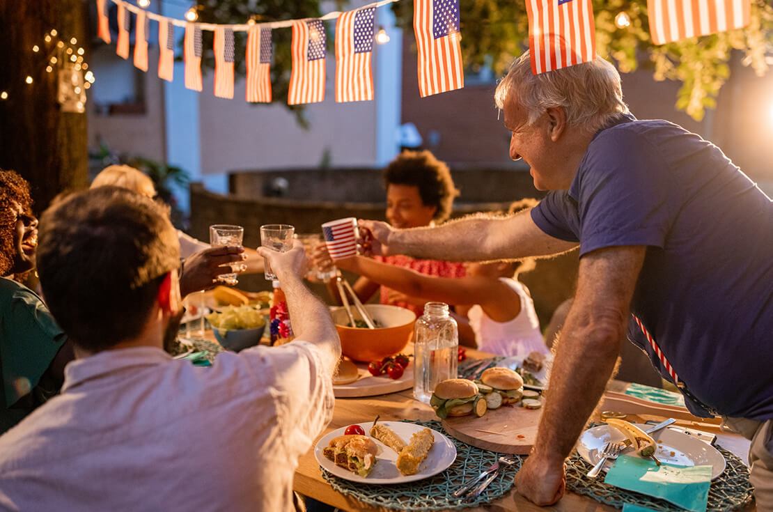 family having dinner outdoors on an American national holiday