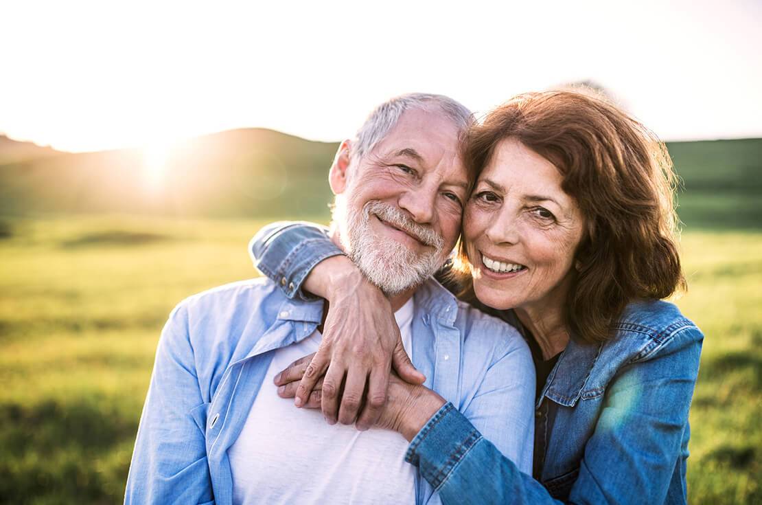 Senior couple outside in spring nature at sunset